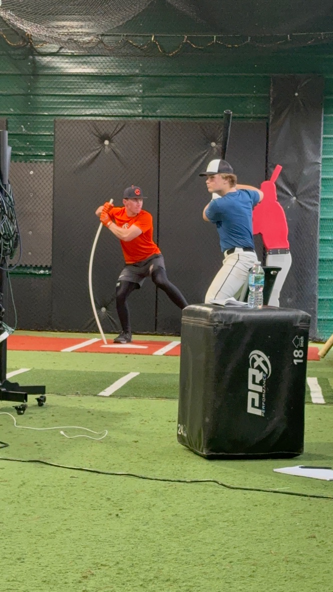 A hitter working with an FBR coach at camp